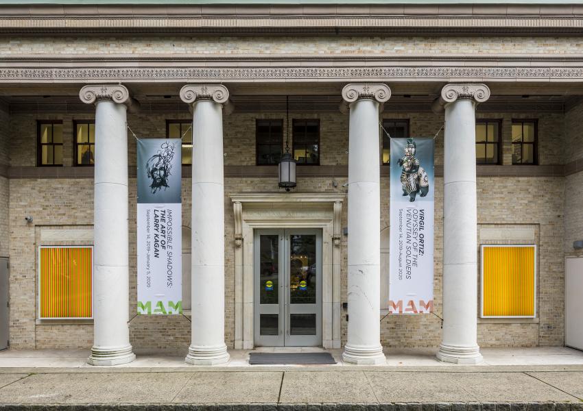 exterior photo of the Museum featuring banners of Virgil Ortiz and Larry Kagan