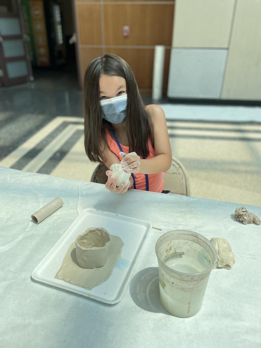 A student working on a handbuilt ceramic bowl.