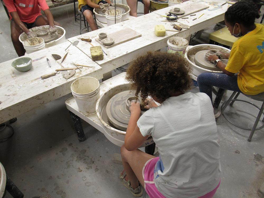 Young students working on pottery wheels in one of MAM's wheel throwing classes