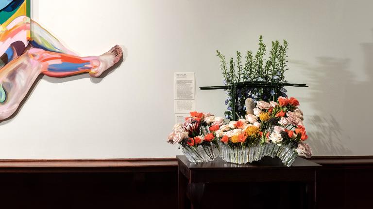 A floral arrangement next to a piece of modern at in MAM's galleries.