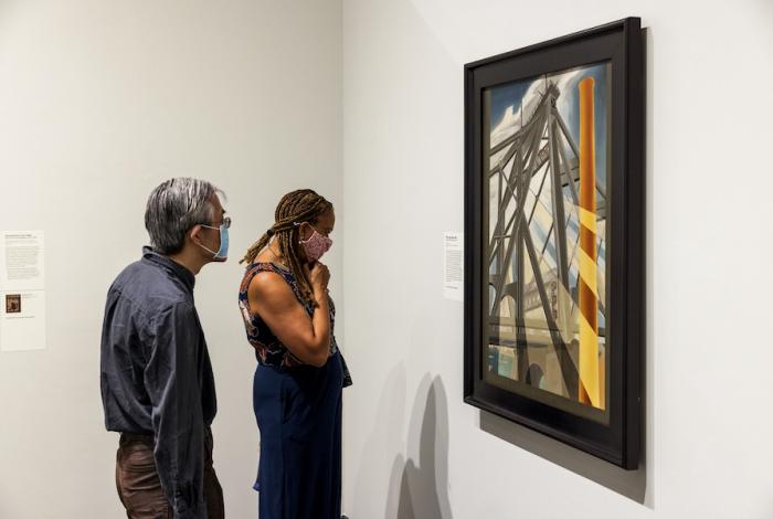 Two visitors are looking at an artwork in the exhibition Transformed: Objects Reimagined by American Artists.