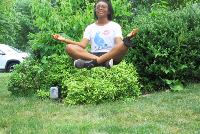 A student appears to be levitating above the grass in a seated position—after editing the photo in Digital Photography class. 