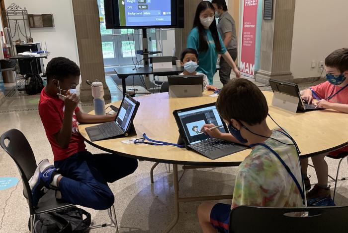 Students sitting around a table using Surface Pro tablets. 
