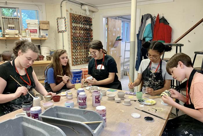 Group of teens painting their recently fired ceramics projects in MAM's Ceramic Studio